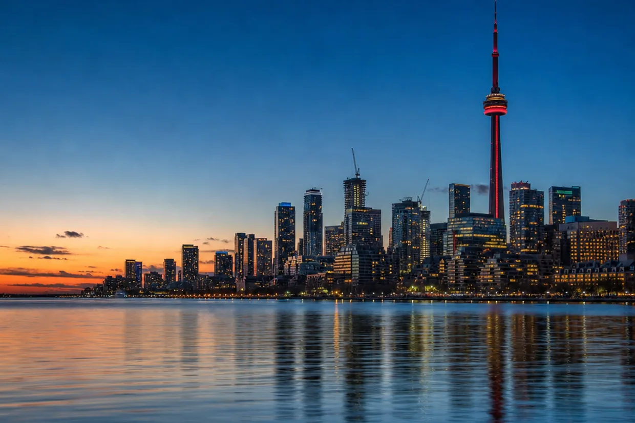 The Toronto lakeshore skyline reflected on Lake Ontario at dusk, the far-end destination for a Georgia-to-Canada long-haul