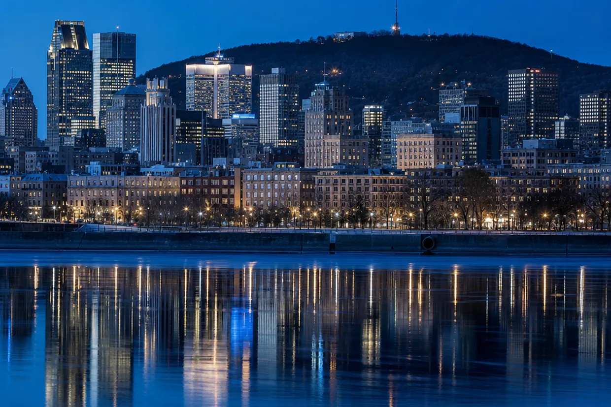 Montreal skyline reflected in the St. Lawrence River at blue hour, with Mount Royal silhouetted behind the downtown towers