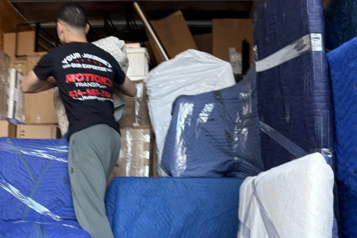Motion Transport mover securing blanket-wrapped furniture inside the truck for a long distance move